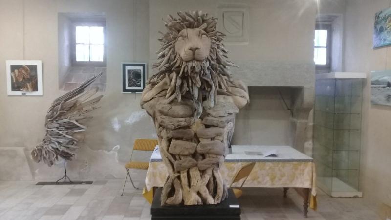 Un artiste français travaillant sur une grande sculpture d'animal en bois flotté, montrant le processus créatif et l'attention aux détails de la sculpture bois flotté animaux.